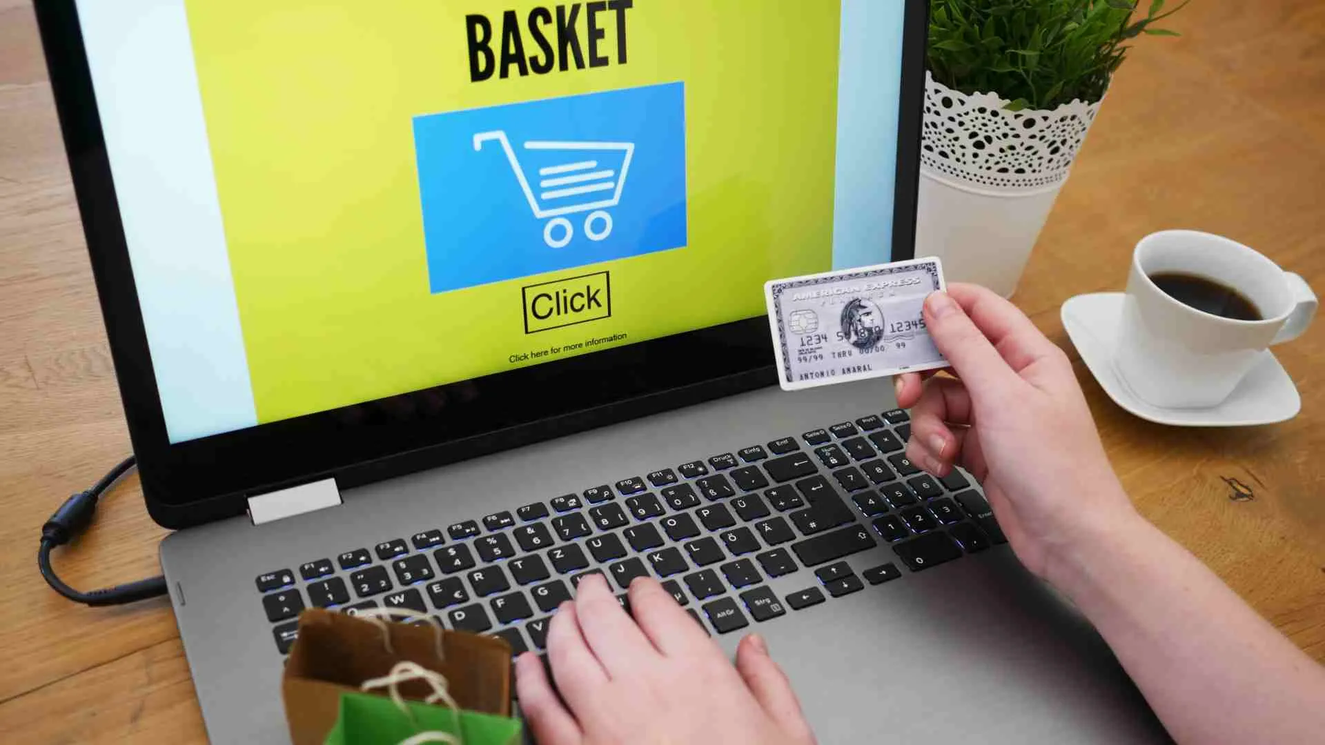 Persona introduciendo los datos de su tarjeta bancaria en un portátil para hacer una compra online